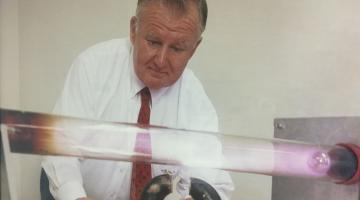 Paul Thomas moves a magnet beneath a glowing plasma in a discharge tube, one of the many demonstrations he built as part of his Mr. Magnet Science Show.Photo: Paul Rivenberg