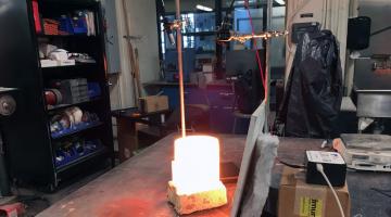 Molten lava in crucible placed under experimental setup. Setup includes a spectrometer (right) which measures the light from the lava at different wavelengths.Image: Tajana Schneiderman